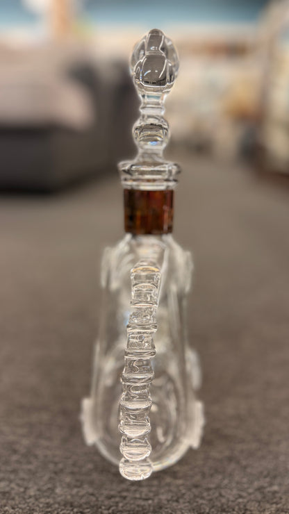 An iconic collector's glass decanter featuring ribbed side flanges, raised medallions, and a Fleur-de-lis crystal stopper in excellent condition.