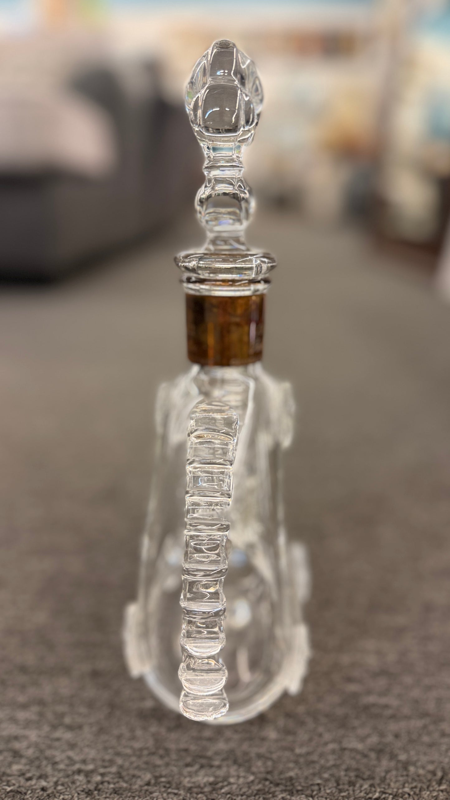 An iconic collector's glass decanter featuring ribbed side flanges, raised medallions, and a Fleur-de-lis crystal stopper in excellent condition.