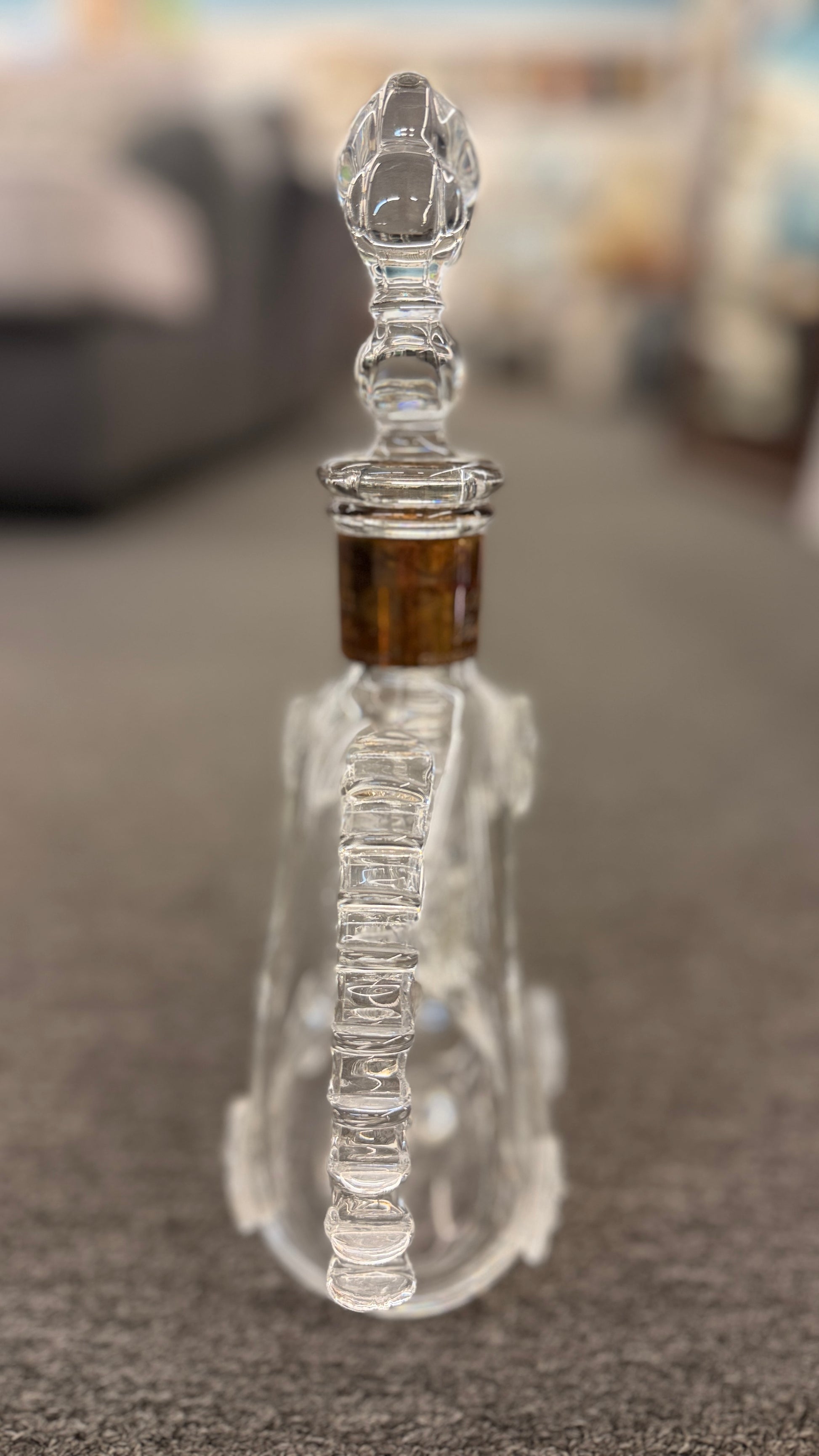 An iconic collector's glass decanter featuring ribbed side flanges, raised medallions, and a Fleur-de-lis crystal stopper in excellent condition.