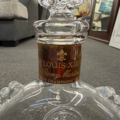 An iconic collector's glass decanter featuring ribbed side flanges, raised medallions, and a Fleur-de-lis crystal stopper in excellent condition.