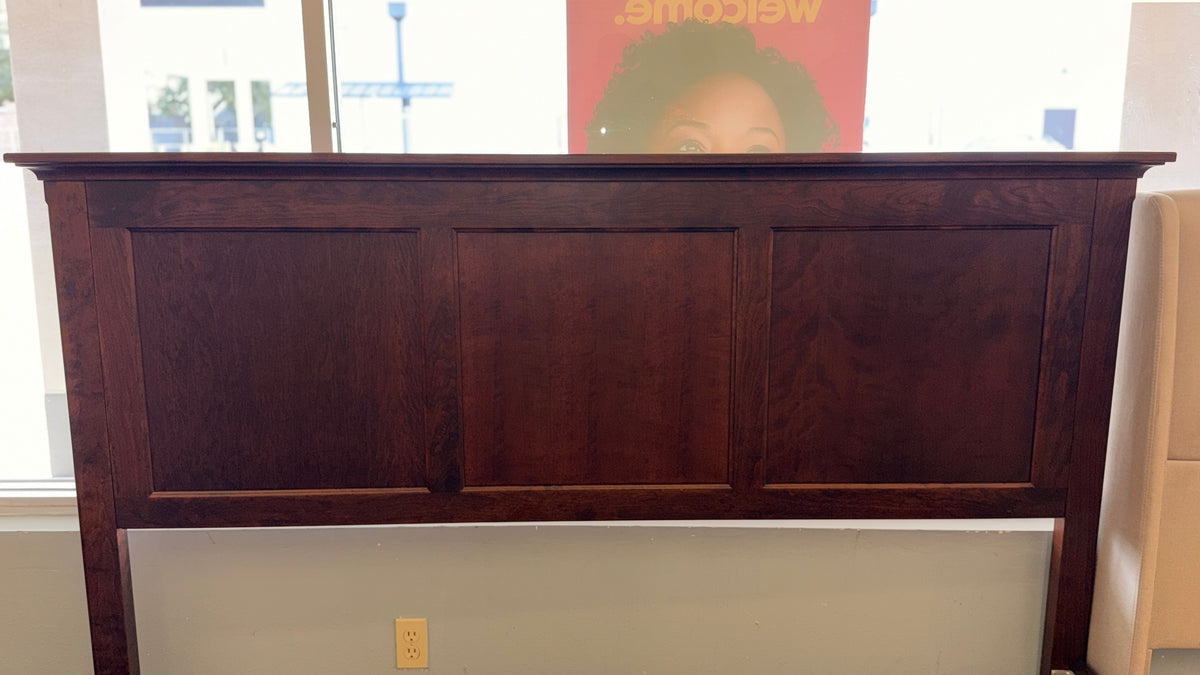 A substantial king-sized wooden bed frame in an espresso finish featuring a high panel headboard, matching footboard, side rails, and supportive slats in excellent condition.
