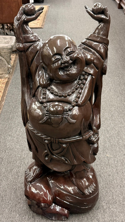 Large joyful synthetic laughing Buddha statement statue with raised arms and a wood-look finish on a gray floor at 2nd Debut Houston consignment showroom