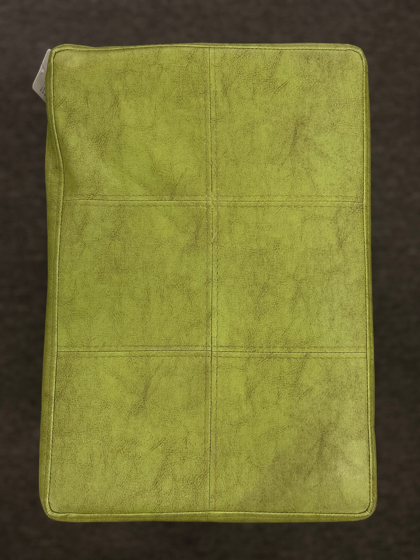 A wooden backless barstool featuring a lime green cushioned leather seat with brass nailhead accents in good condition.