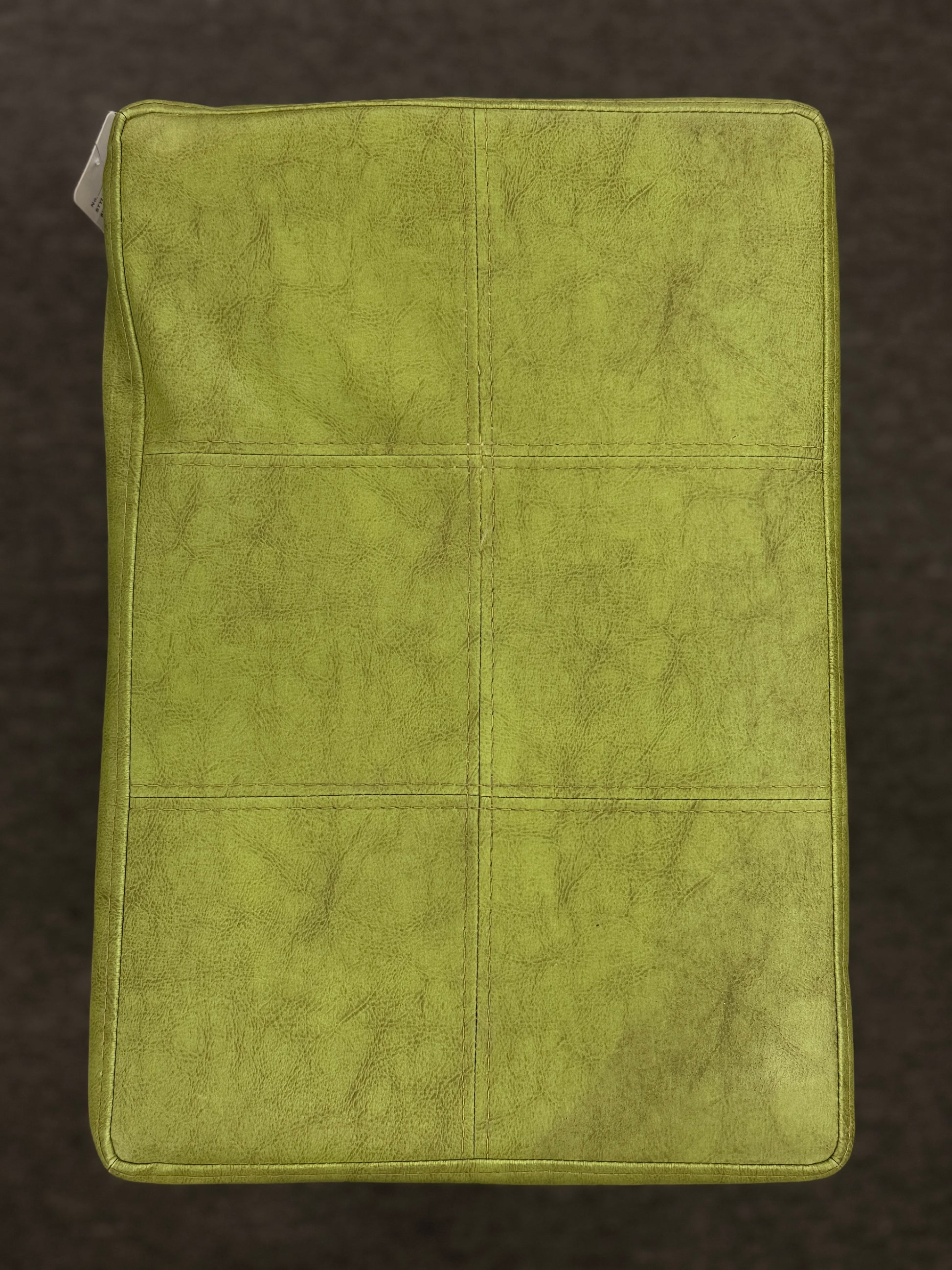 A wooden backless barstool featuring a lime green cushioned leather seat with brass nailhead accents in good condition.