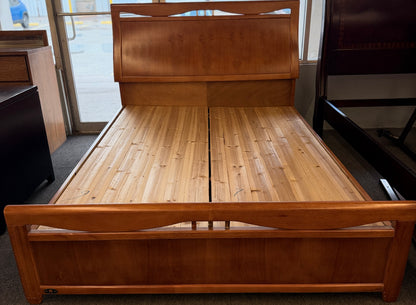A mid-century modern full bed frame made of wood, featuring a gently curved headboard, footboard, and a sturdy interior slatted support base.