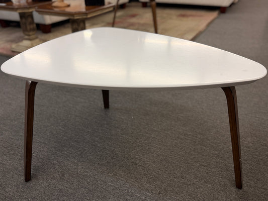 A retro-inspired triangular end table featuring a smooth white guitar-pick-shaped top supported by three splayed, tapered dark wood legs.