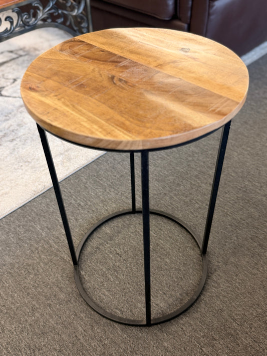 A minimalist round side table featuring a light wood tabletop and a black metal frame in excellent condition.