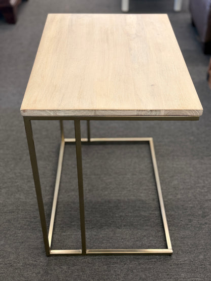 A minimalist C-shaped end table with a wooden tabletop and a slender black metal frame designed to slide over a sofa arm.