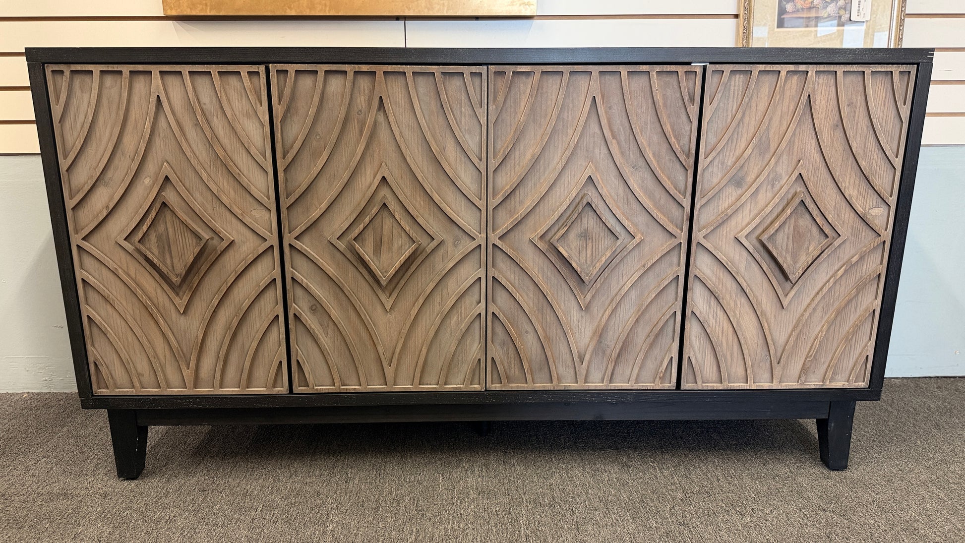 A modern 4-door credenza sideboard with an intricate, carved geometric design featuring concentric diamond and arched wave patterns across the door fronts.