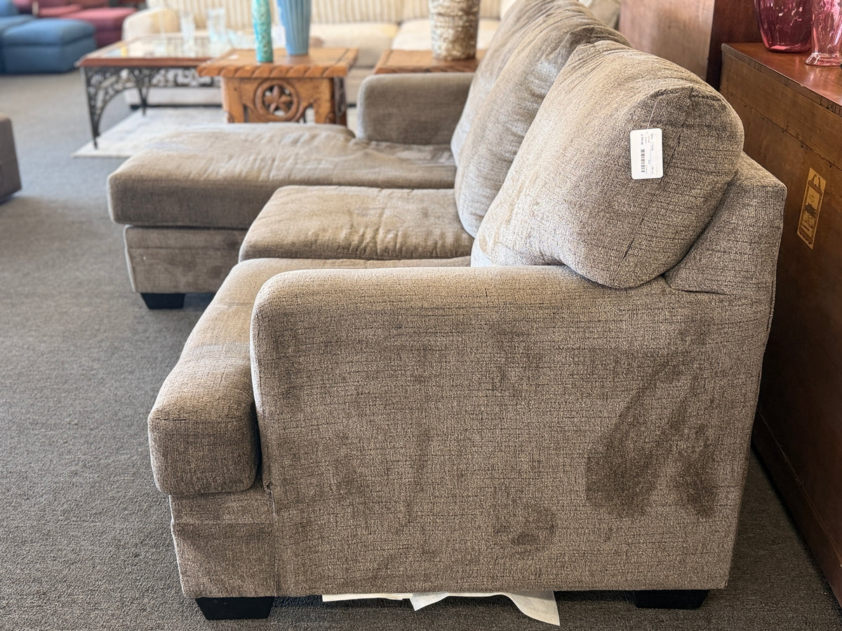 A modern casual sectional sofa upholstered in textured beige-gray chenille fabric featuring an extended chaise lounge in excellent condition.