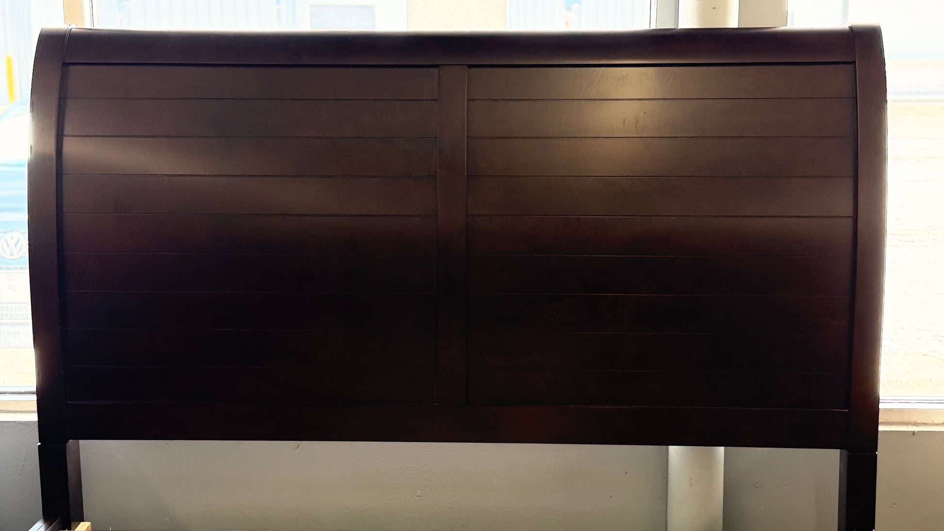 A modern dark-wood queen platform bed frame with a horizontal-paneled headboard, six footboard storage drawers, and matching three-drawer nightstands.
