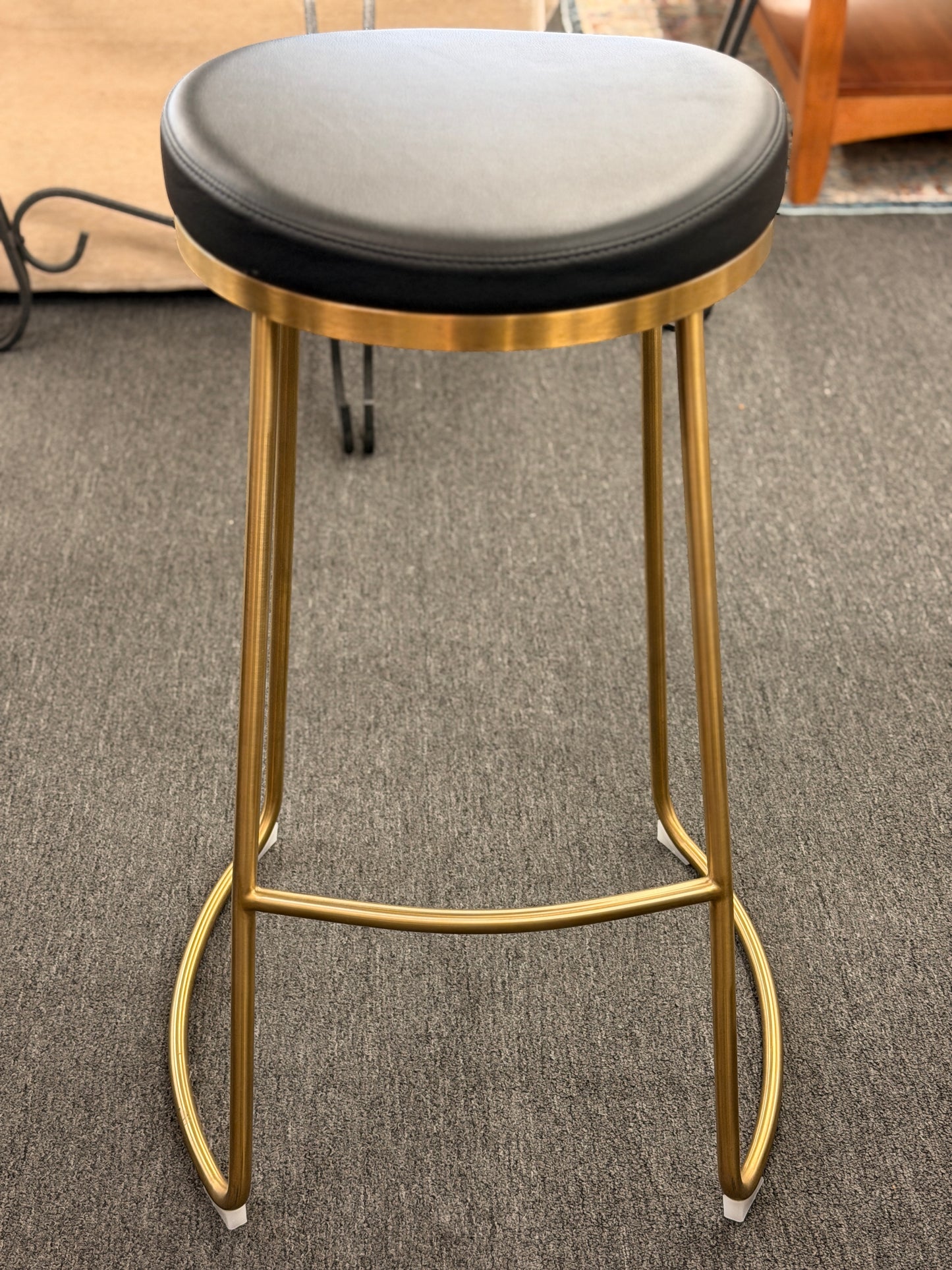 Modern geometric brass and black leather barstool set featuring slender metal legs and a half circle footrest at 2nd Debut Houston consignment showroom
