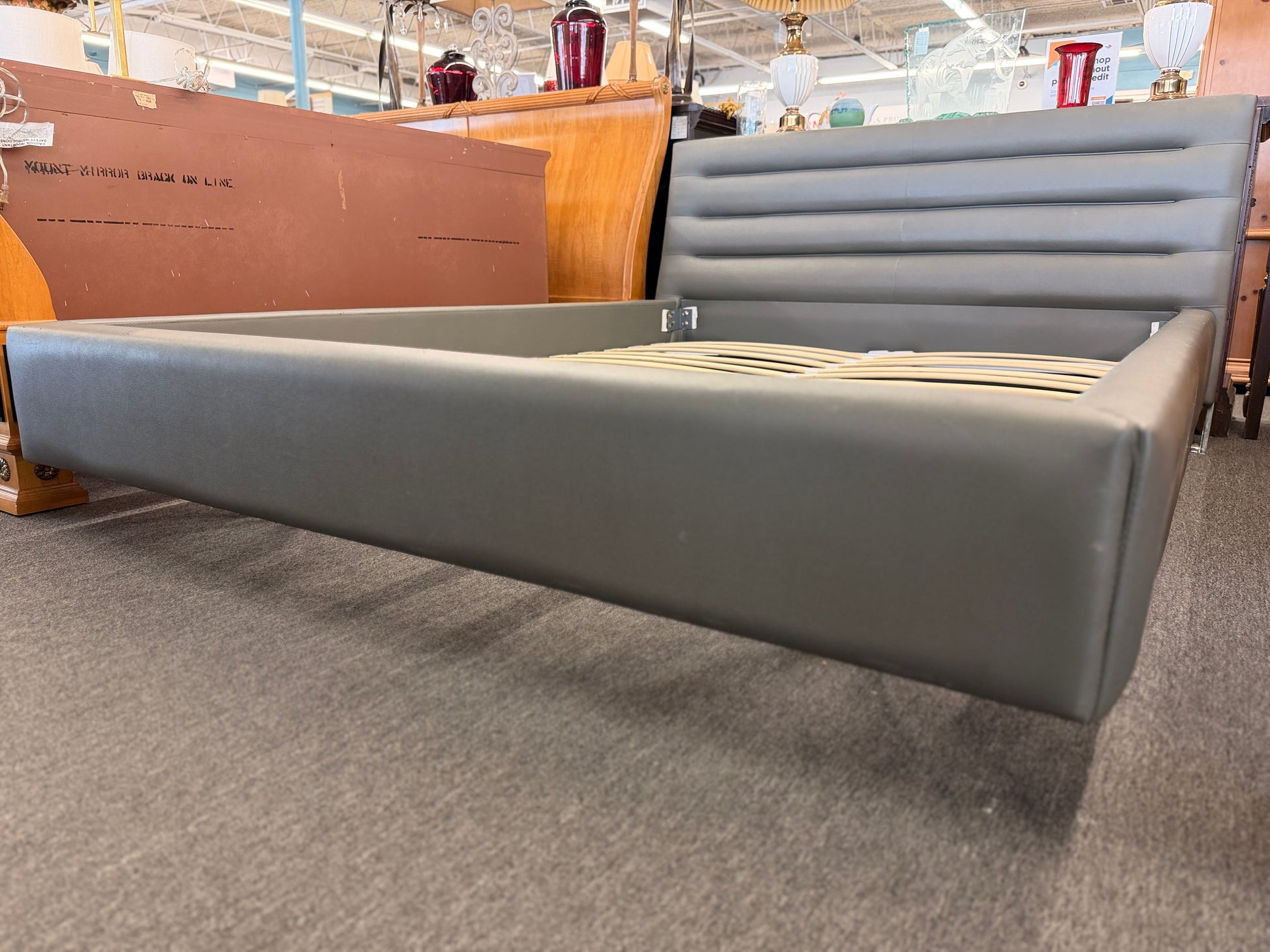 Modern gray upholstered queen platform bed featuring a horizontal channel tufted headboard and wooden slat mattress support without a box spring.
