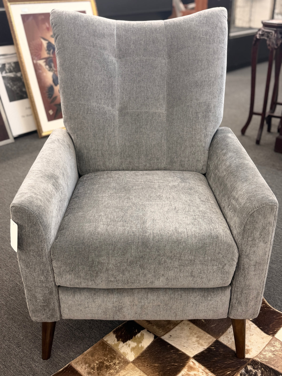 A sleek push-back recliner chair upholstered in heather-gray textured fabric featuring track arms, subtle vertical tufting, and tapered dark wood legs in excellent condition.