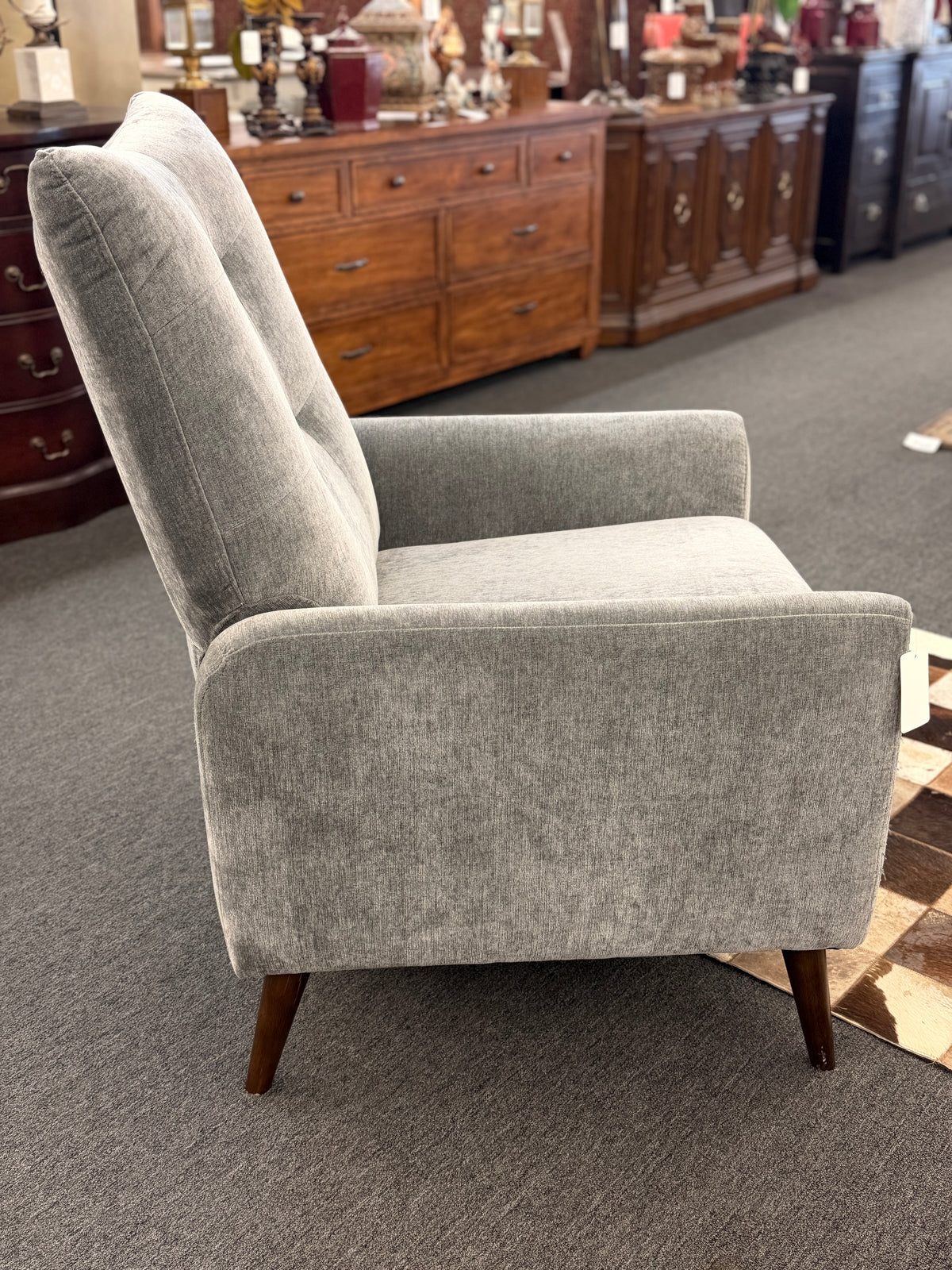 A sleek push-back recliner chair upholstered in heather-gray textured fabric featuring track arms, subtle vertical tufting, and tapered dark wood legs in excellent condition.