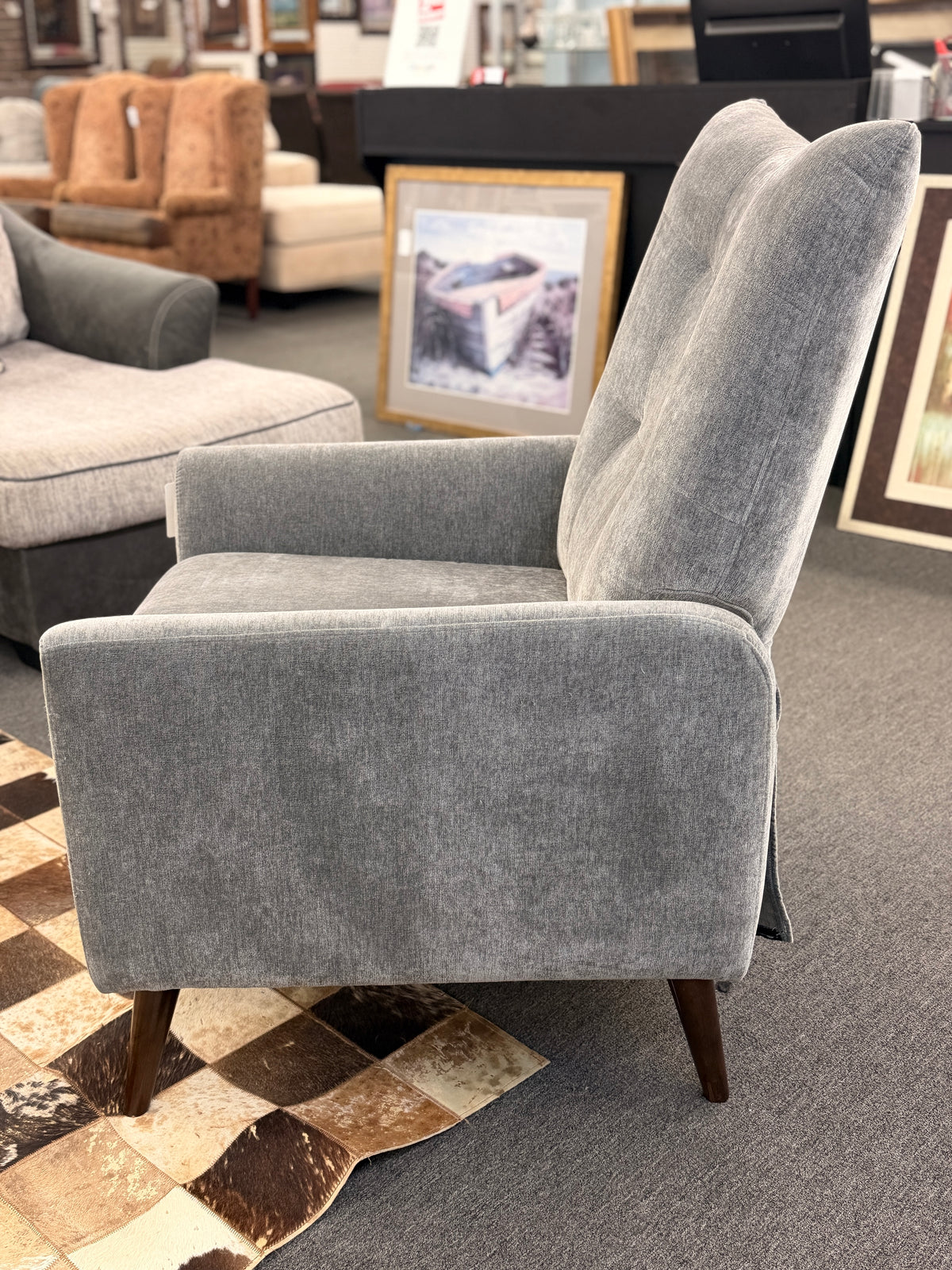 A sleek push-back recliner chair upholstered in heather-gray textured fabric featuring track arms, subtle vertical tufting, and tapered dark wood legs in excellent condition.