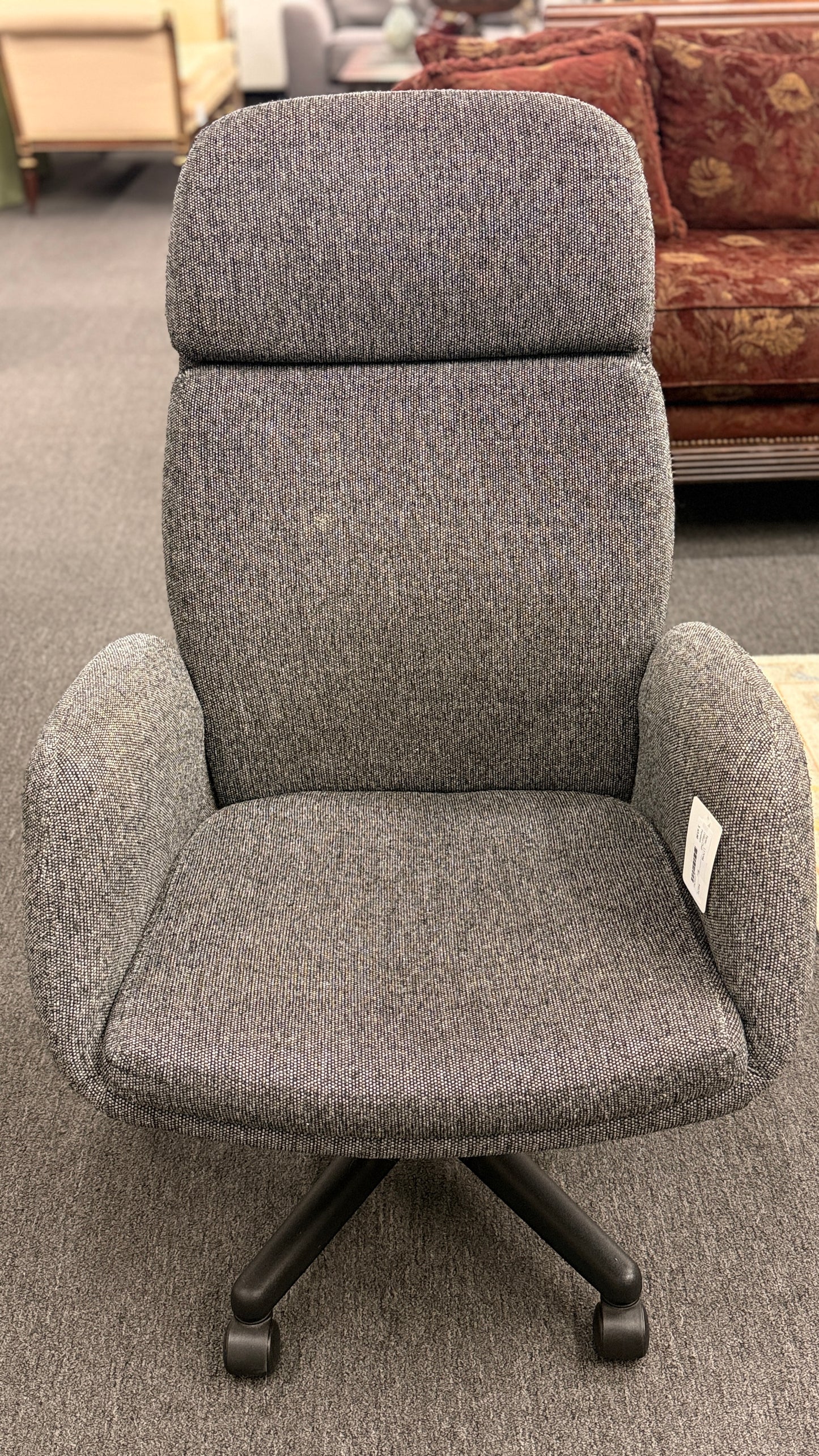 A modern minimalist high-back swivel office chair upholstered in textured grey fabric on a dark five-point wheeled base.