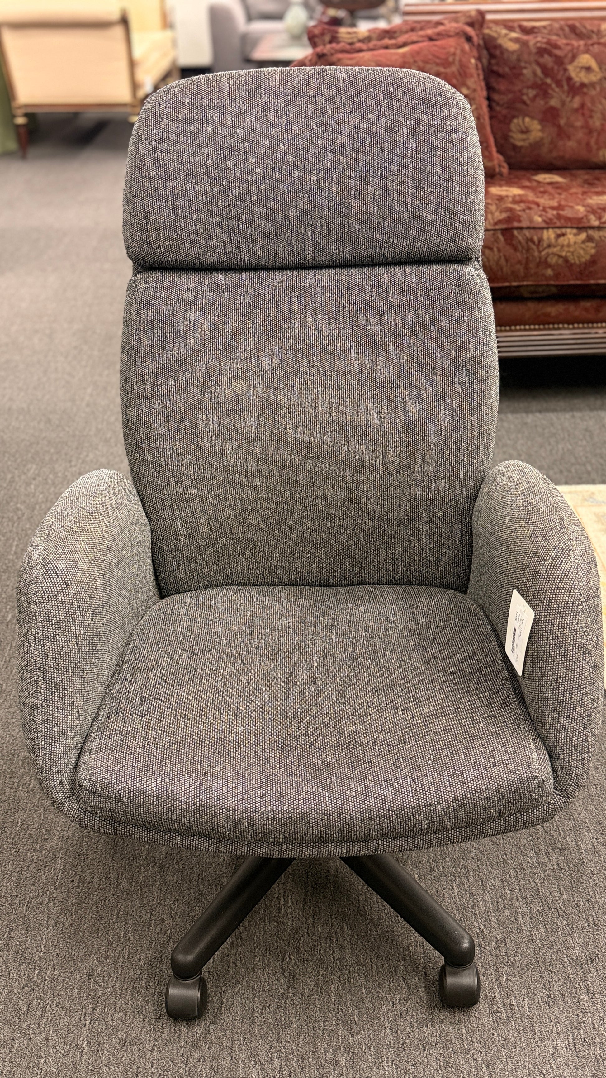 A modern minimalist high-back swivel office chair upholstered in textured grey fabric on a dark five-point wheeled base.