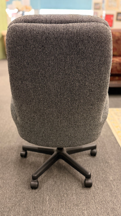 A modern minimalist high-back swivel office chair upholstered in textured grey fabric on a dark five-point wheeled base.