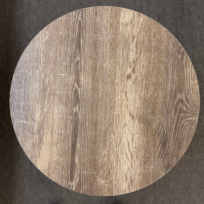 A round two-tiered end table featuring a distressed faux wood-grain finish on both circular shelves with a minimalist black iron frame.