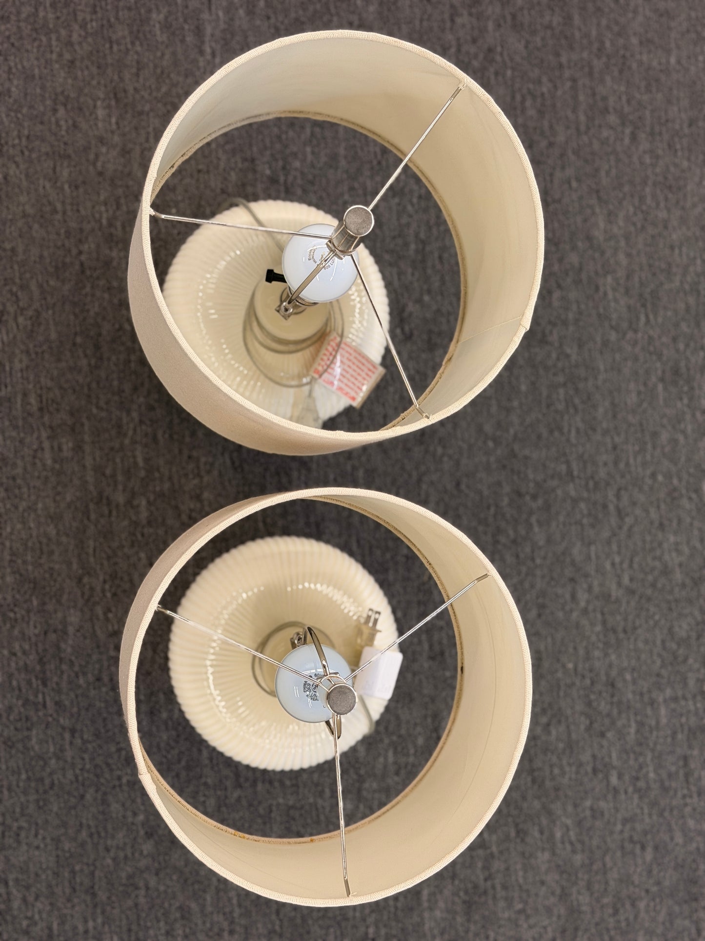 A pair of matching table lamps featuring textured spherical ceramic bases and neutral-colored fabric drum shades.