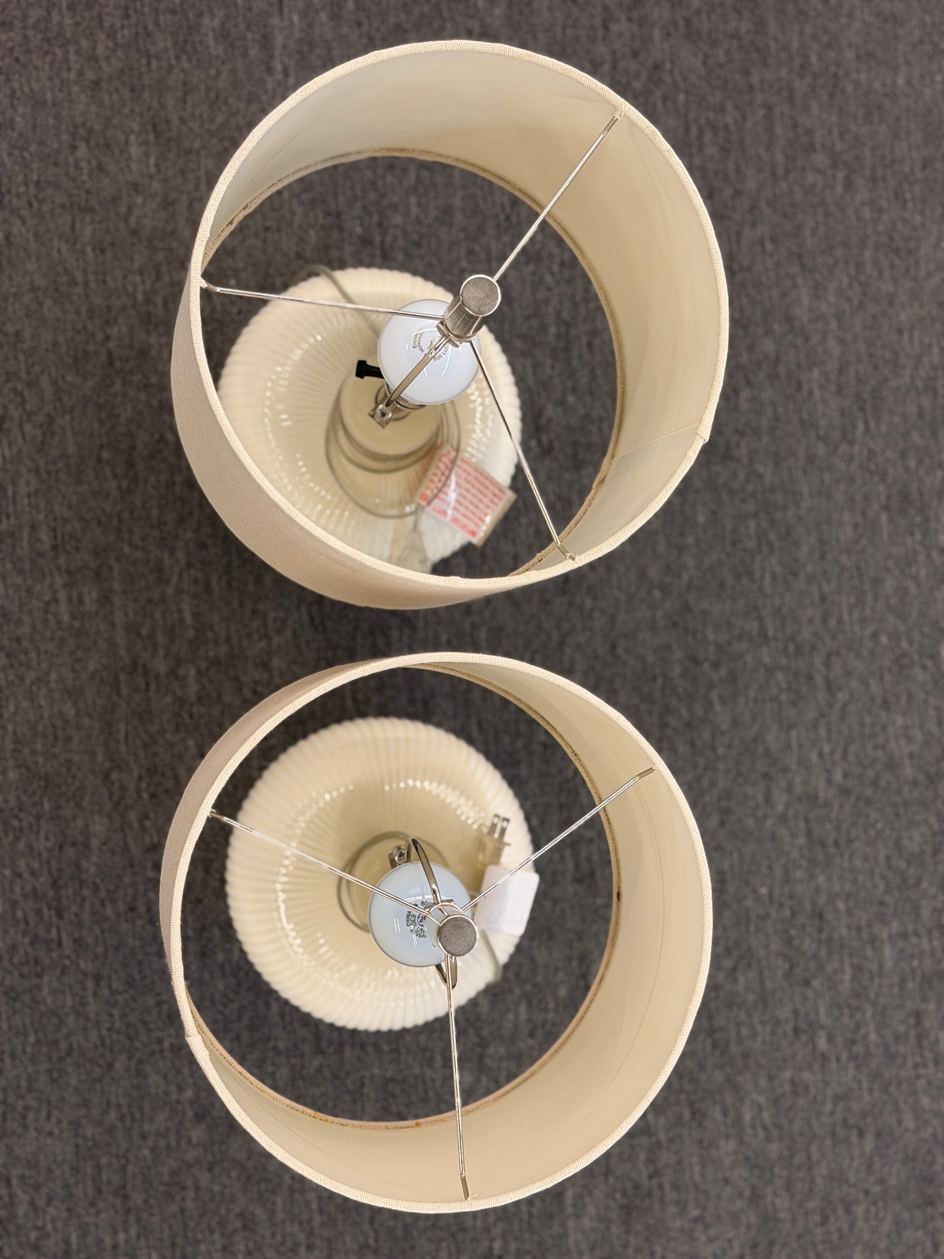 A pair of matching table lamps featuring textured spherical ceramic bases and neutral-colored fabric drum shades.