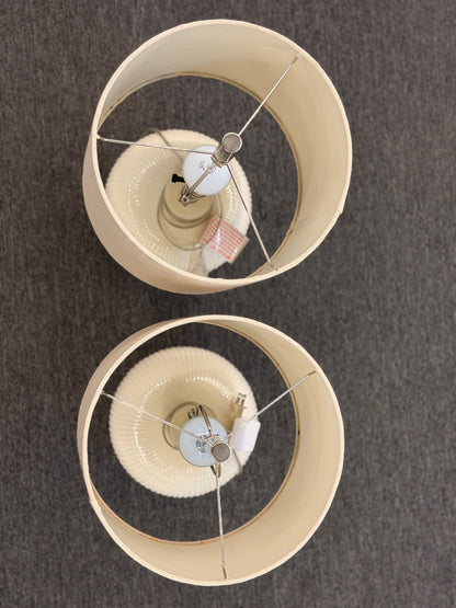A pair of matching table lamps featuring textured spherical ceramic bases and neutral-colored fabric drum shades.