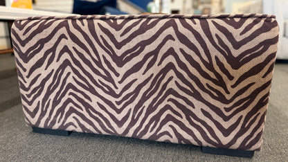 A modern square cube ottoman upholstered in a textured brown and beige zebra-stripe woven fabric in good condition.