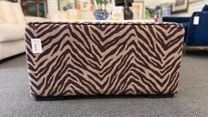 A modern square cube ottoman upholstered in a textured brown and beige zebra-stripe woven fabric in good condition.