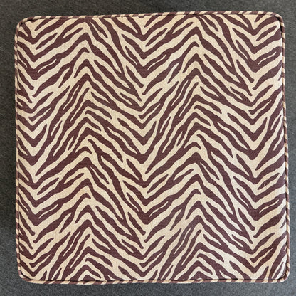A modern square cube ottoman upholstered in a textured brown and beige zebra-stripe woven fabric in good condition.