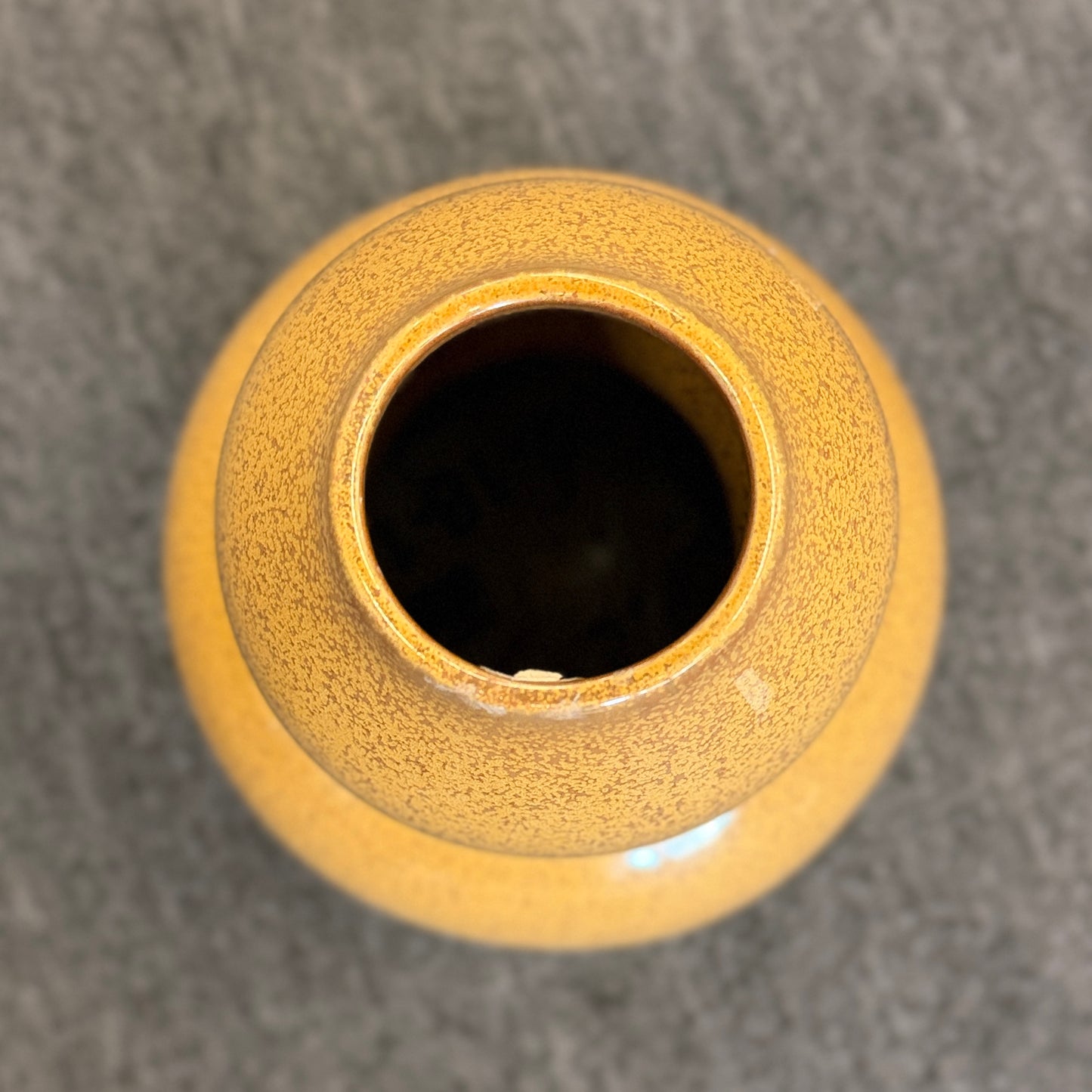A double-gourd shaped ceramic vase in a mustard-yellow hue featuring a glossy speckled glaze finish.