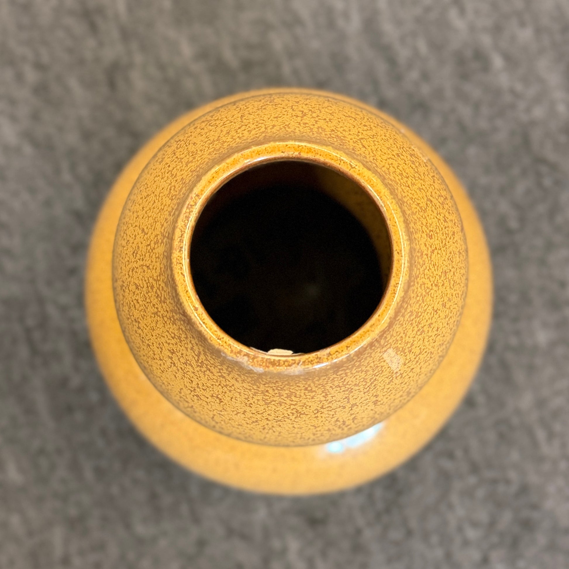 A double-gourd shaped ceramic vase in a mustard-yellow hue featuring a glossy speckled glaze finish.