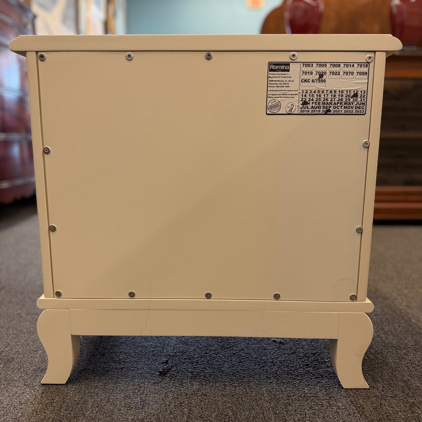 An off-white wooden nightstand featuring a single drawer with a turned knob, an open lower cubby, and curved cabriole legs.