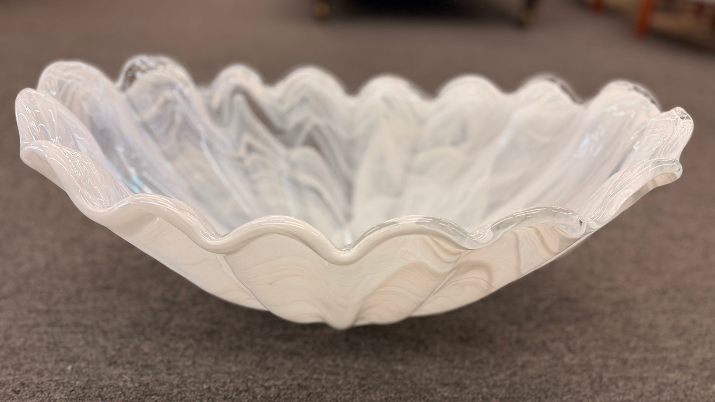 An elegant 20-inch wide decorative glass centerpiece bowl in an opalescent milky-white color, featuring a deeply ruffled and scalloped edge shaped like a sea shell.