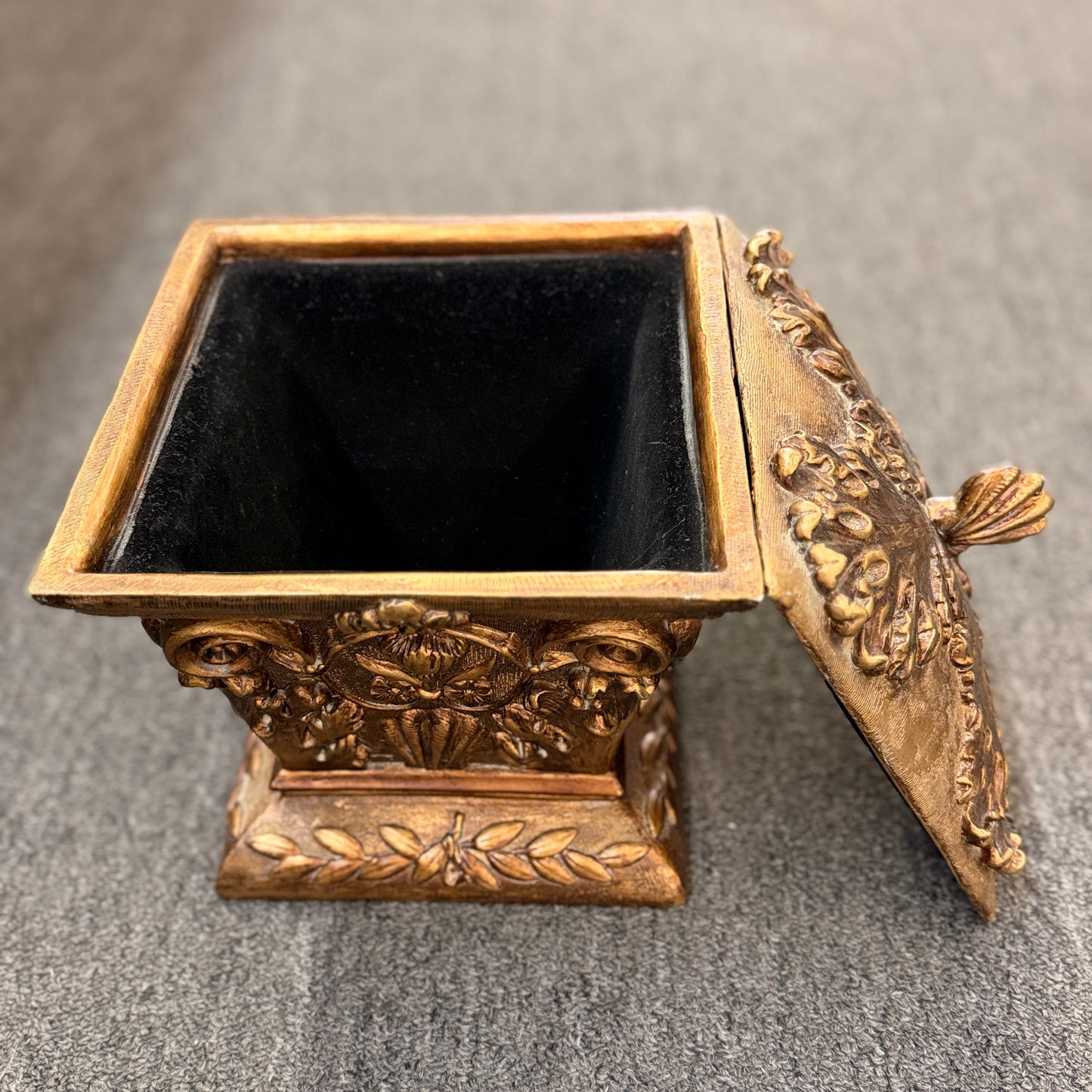 An ornate antique-style ceramic decorative box with a lid, featuring classical floral relief motifs and a distressed gold finish.