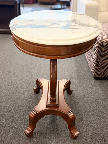 An ornate accent table featuring a white marble top, carved floral apron details, and a traditional lyre-shaped wooden base in excellent condition.