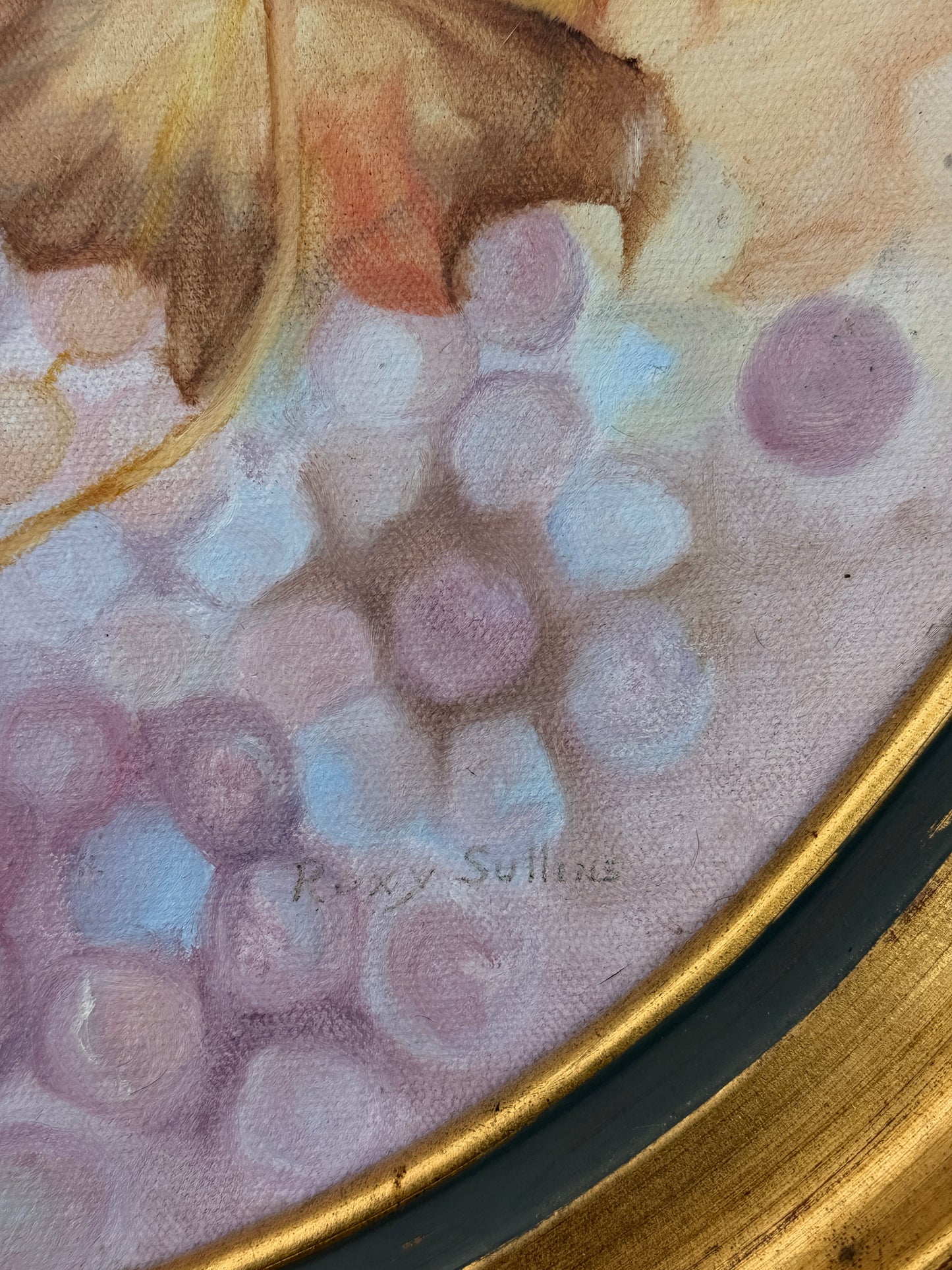 Oval framed still life artwork depicting a colorful cluster of grapes and leaves in soft pastel tones within a classic wooden frame.