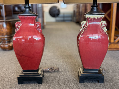 A matching pair of modern table lamps featuring ceramic bodies, wood bases, and fabric shades in excellent condition.