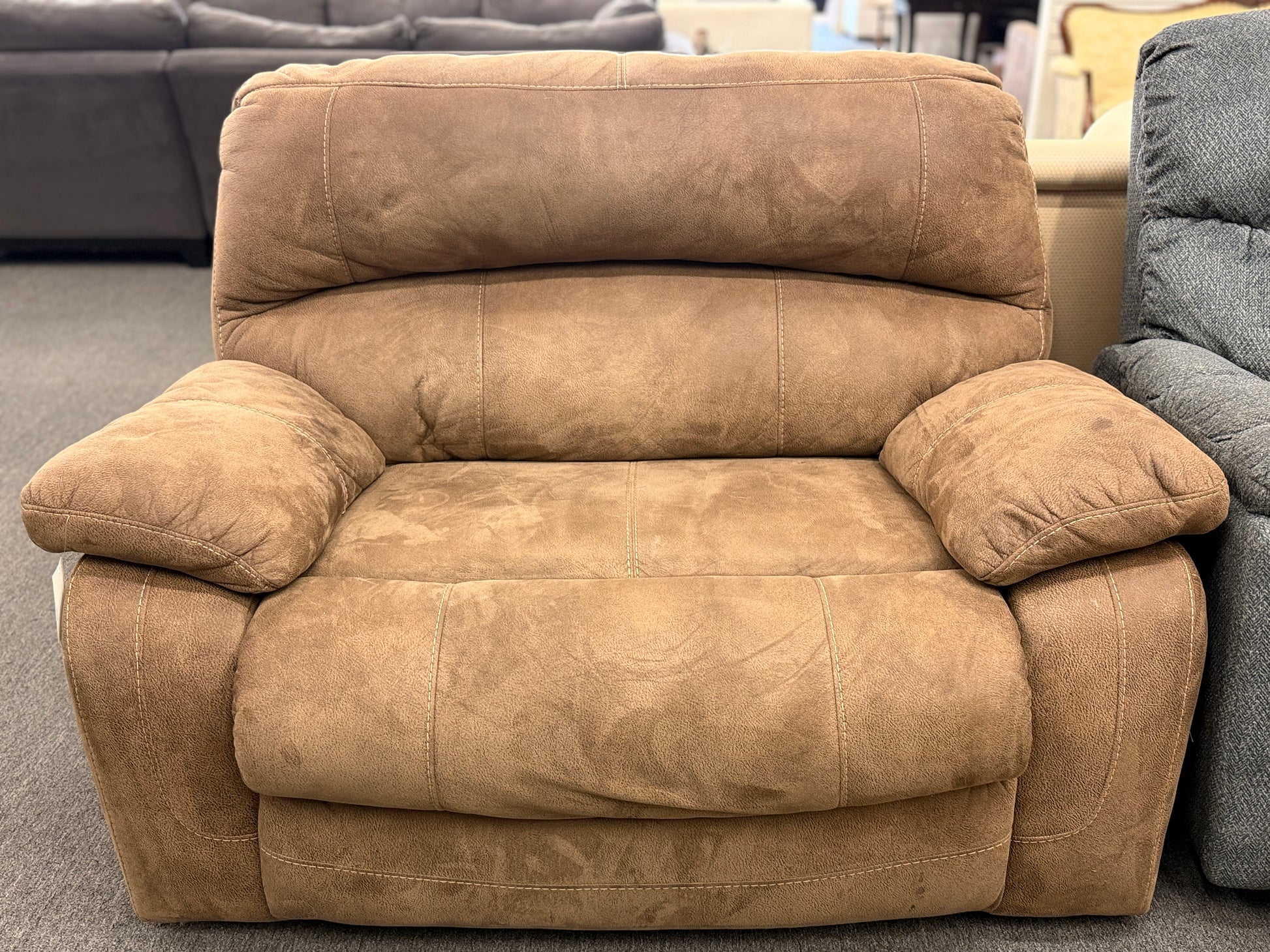 A wide plush power recliner chair featuring a segmented headrest, pillow-top arms, and heavy contrast stitching in good condition.