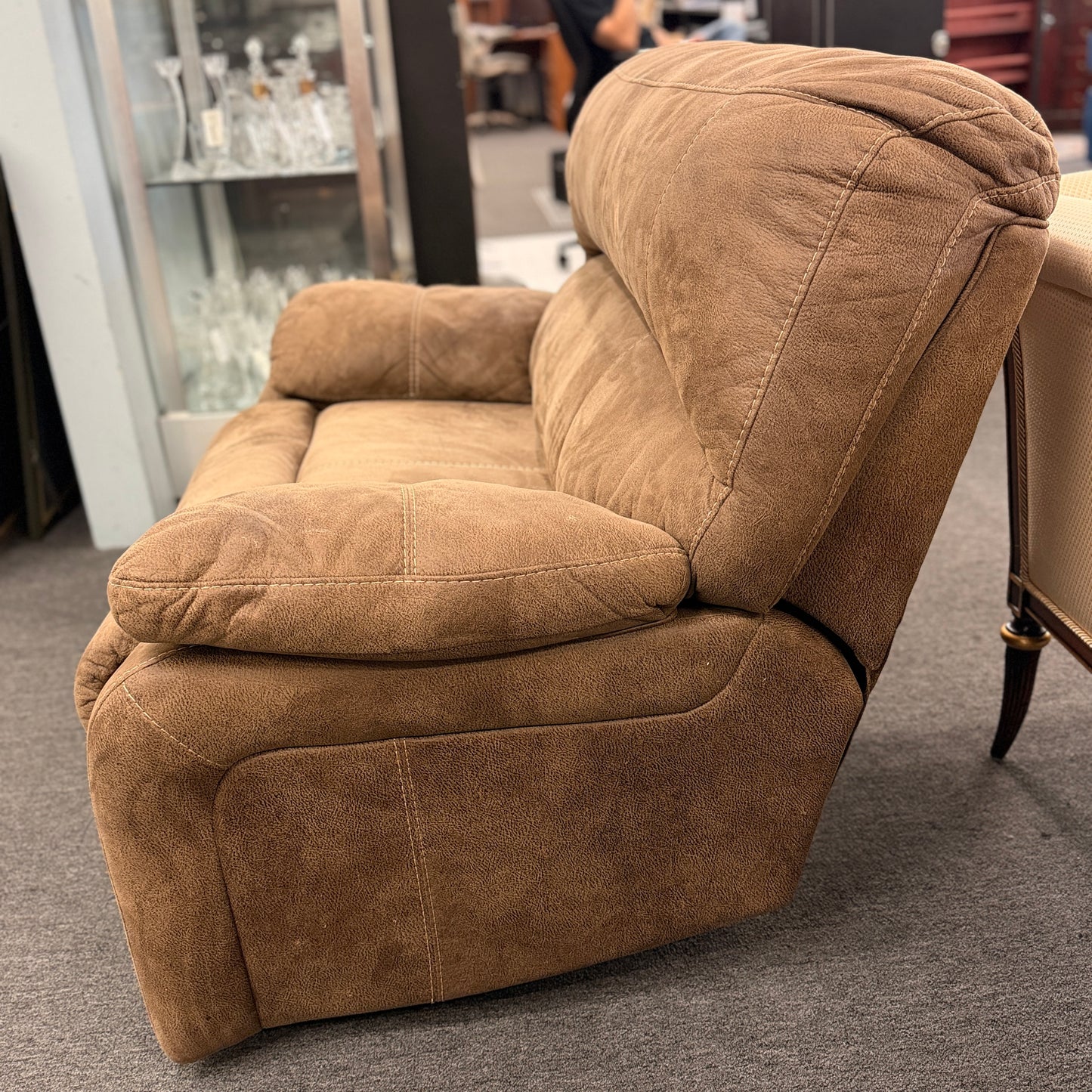 A wide plush power recliner chair featuring a segmented headrest, pillow-top arms, and heavy contrast stitching in good condition.