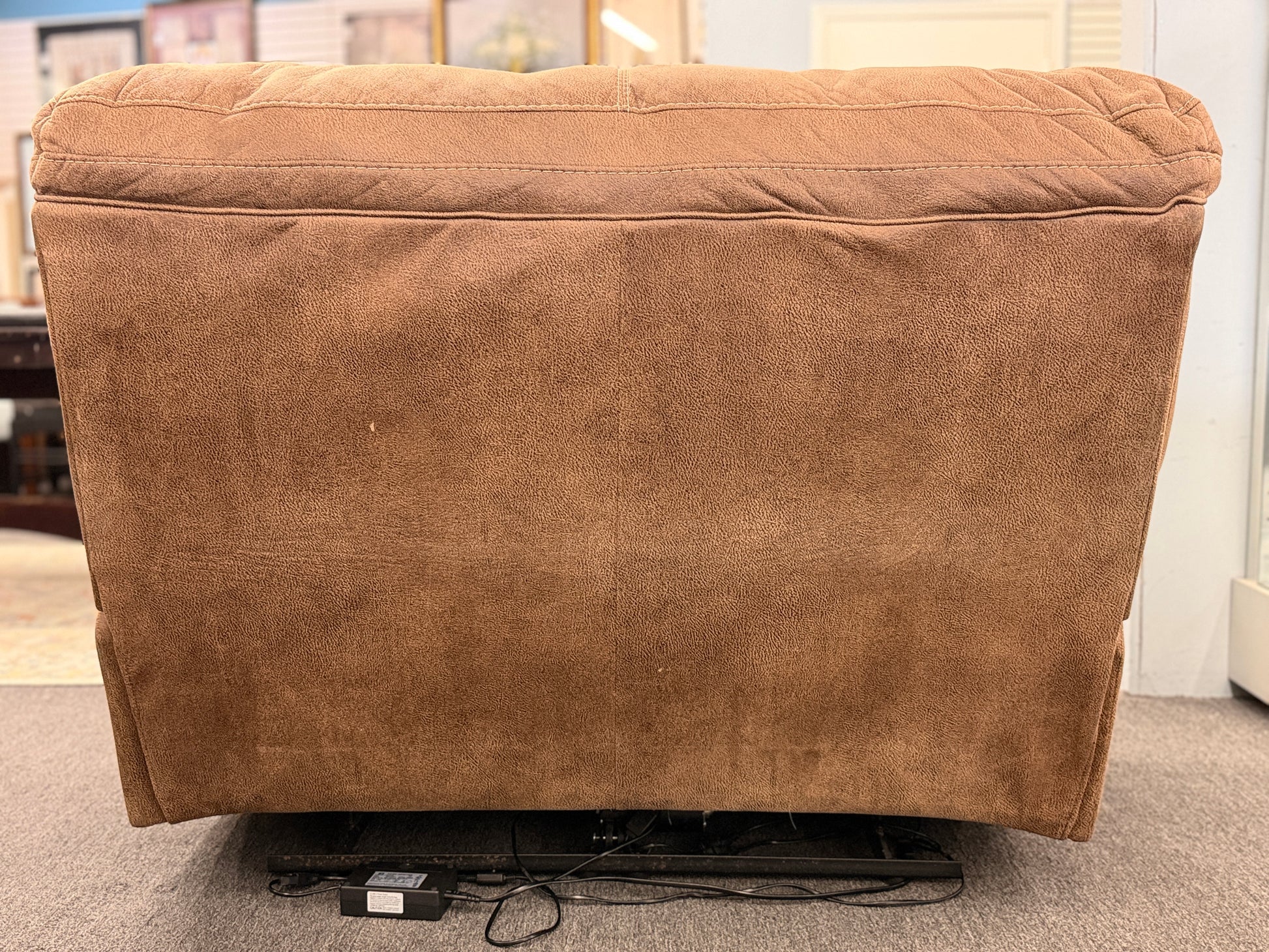 A wide plush power recliner chair featuring a segmented headrest, pillow-top arms, and heavy contrast stitching in good condition.