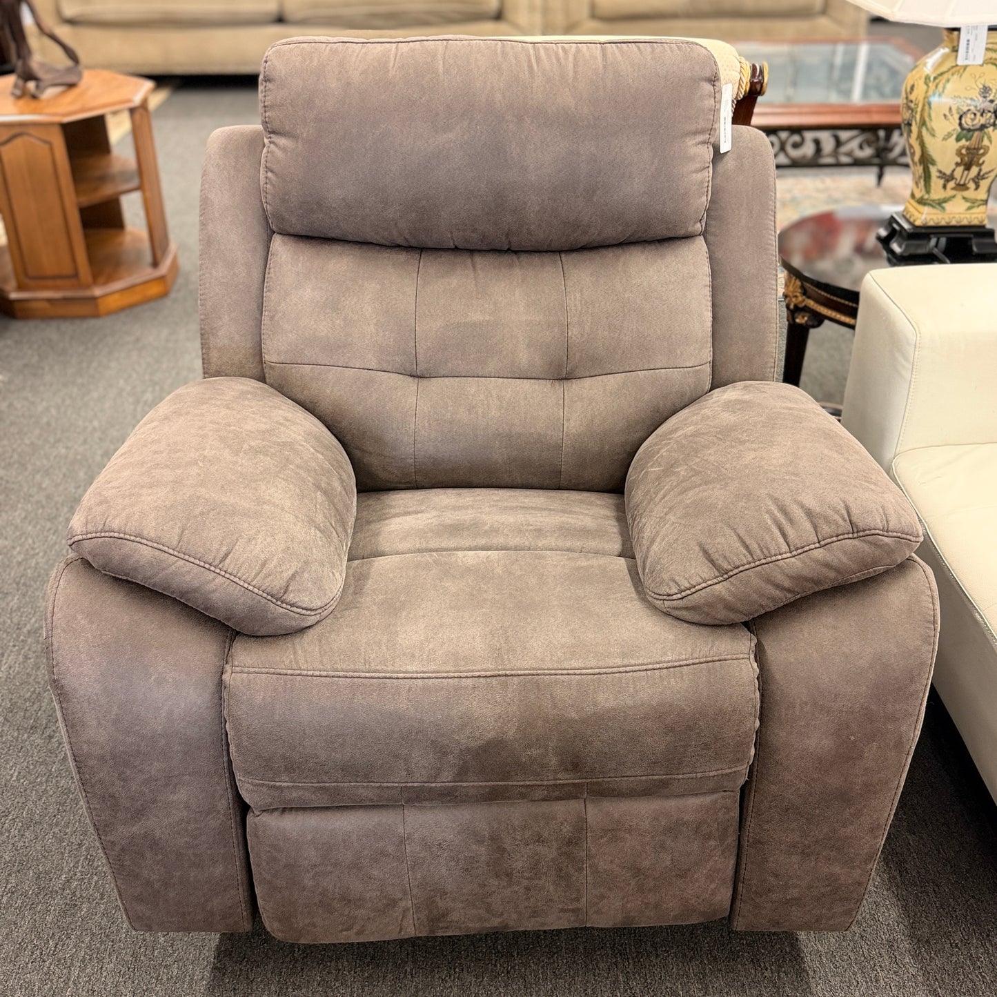 A plush, overstuffed recliner chair in a soft, medium-brown fabric with thickly padded pillow-top armrests and deep back cushioning.