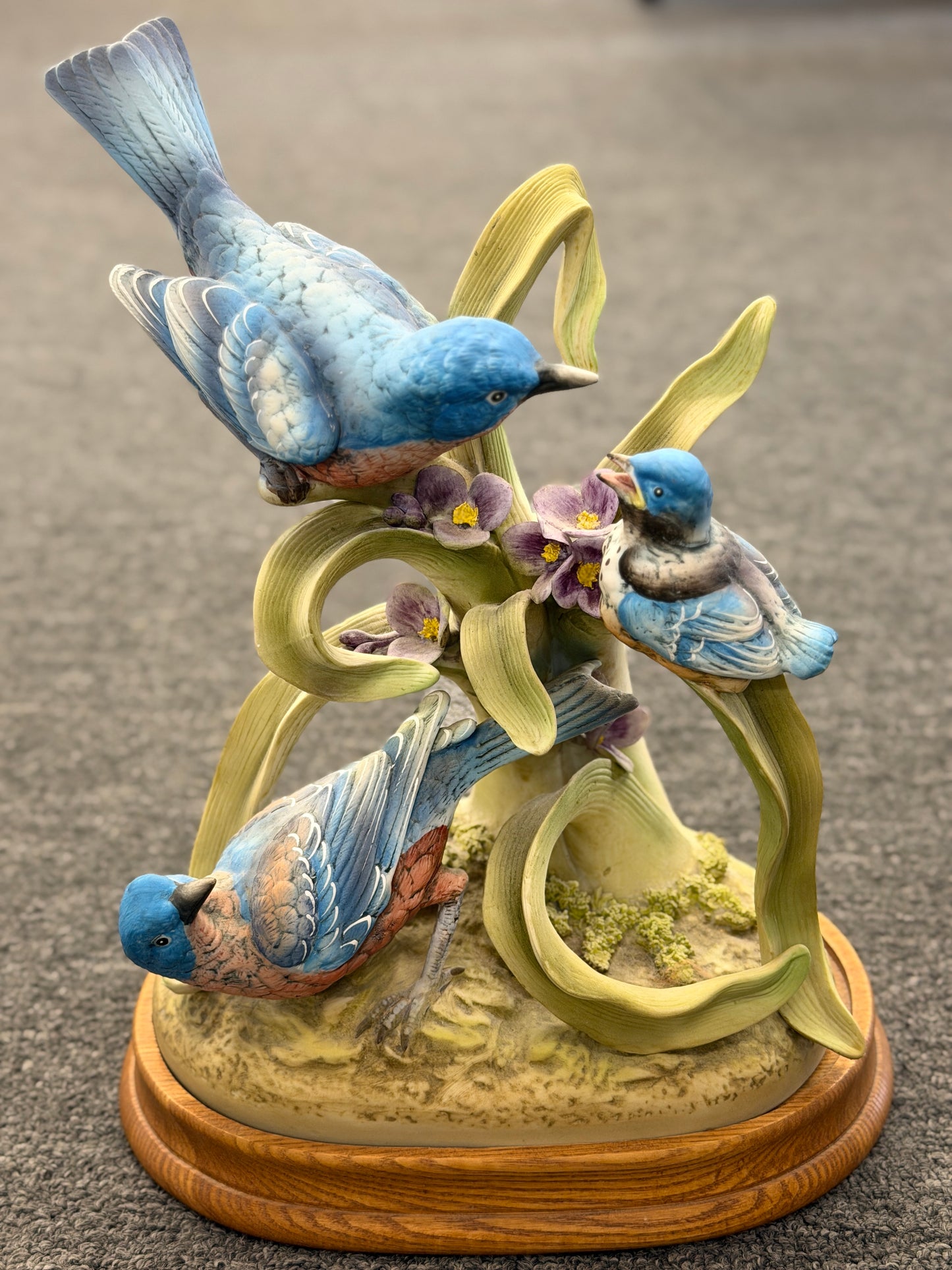 Traditional porcelain figurine depicting three bluebirds on a branch with wildflowers, mounted on a wood base at 2nd Debut Houston consignment showroom