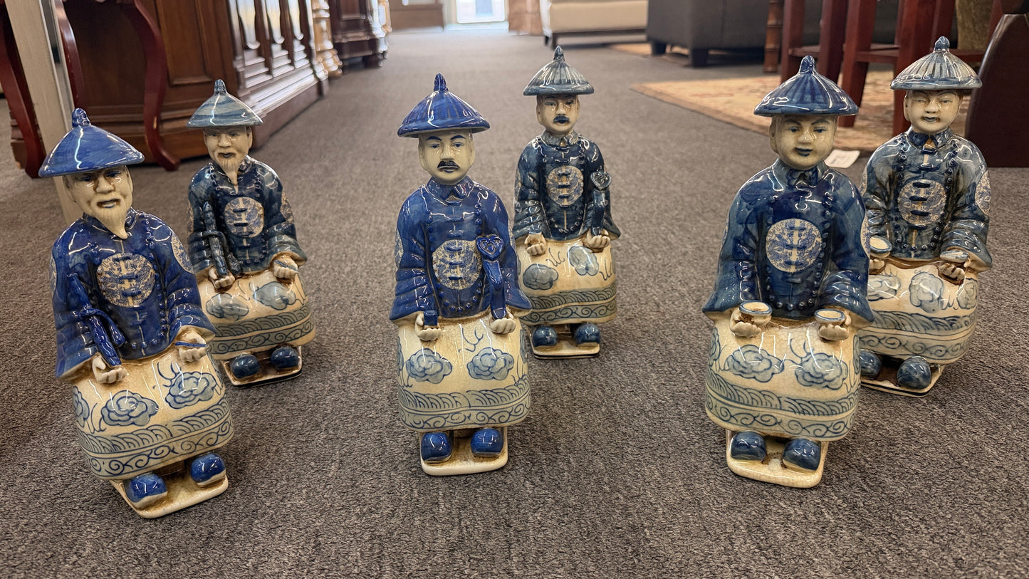 A set of six hand-painted blue and white porcelain figurines depicting seated Qing Dynasty scholars in traditional robes and mandarin hats in excellent condition.