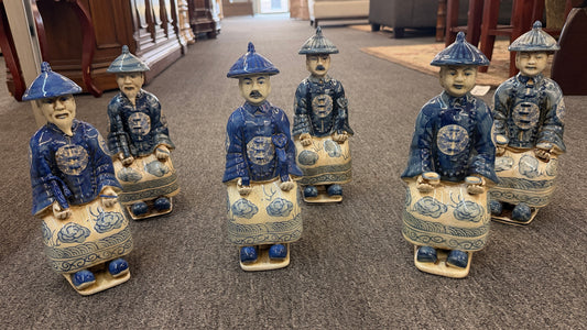 A set of six hand-painted blue and white porcelain figurines depicting seated Qing Dynasty scholars in traditional robes and mandarin hats in excellent condition.