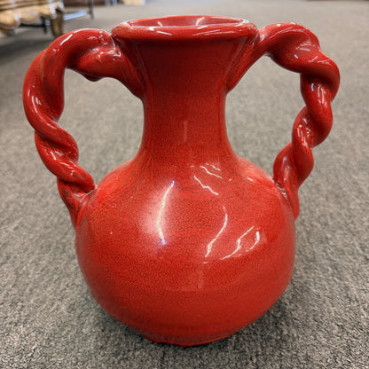 A red crackle-glazed ceramic urn vase featuring two twisted rope handles and a bulbous body in excellent condition.