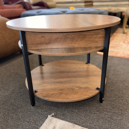 A round tiered wood-finish coffee table featuring a lift-top storage compartment in excellent condition.
