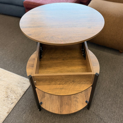 A round tiered wood-finish coffee table featuring a lift-top storage compartment in excellent condition.