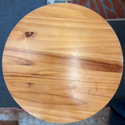 Round accent table featuring a natural wood plank-style top and a slender curved dark metal pedestal base with a lower support ring.
