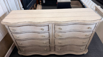 A 4-piece rustic cottage king bedroom set featuring an arched panel headboard bed frame, two nightstands, and a dresser in an antique whitewash finish.